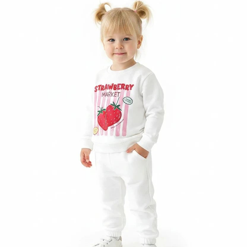 Child wearing a soft cotton Strawberry Market Loungeset with playful strawberry print outdoors