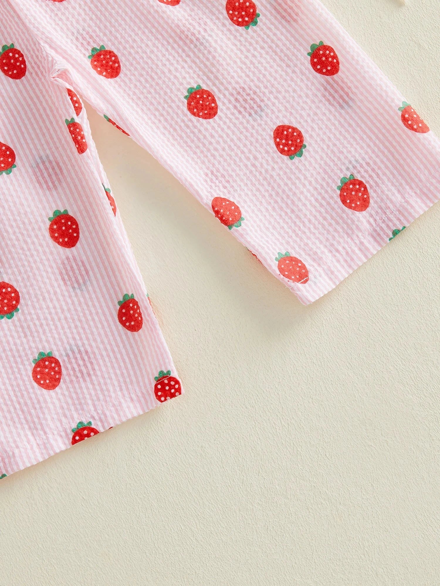 Little girl wearing a lightweight strawberry onesie perfect for summer comfort and breathability